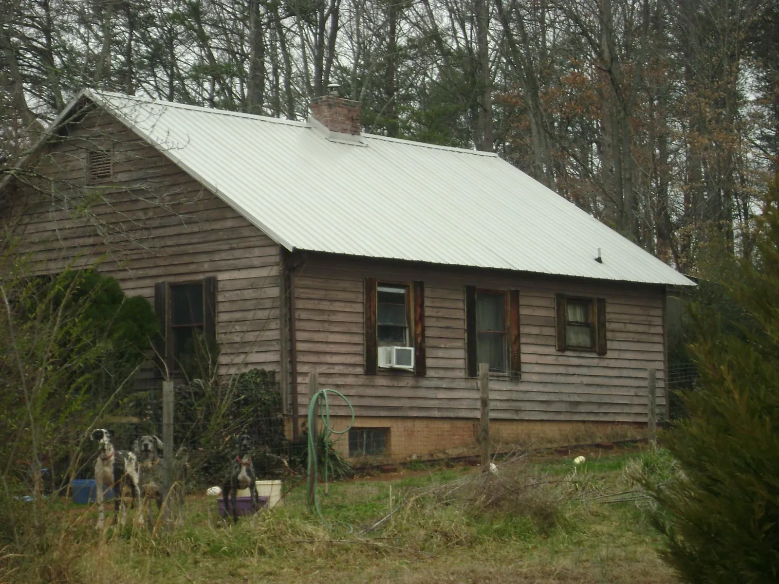 White metal roof on an old wood sided farmhouse, from a Metal Roof Installation job in Riverview